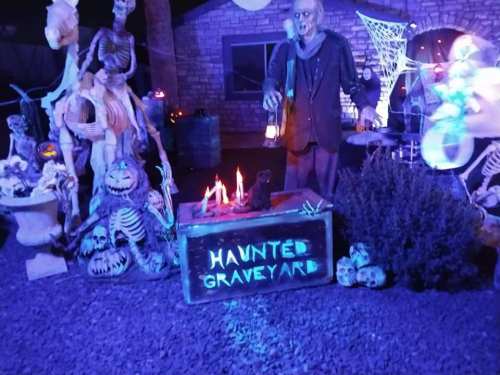 A spooky haunted graveyard scene with skeletons, a zombie figure, and eerie lighting.
