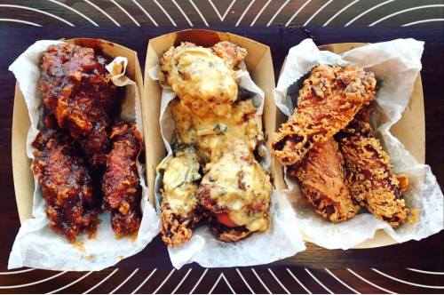 Three trays of chicken wings: one with spicy sauce, one with creamy cheese, and one crispy and golden brown.