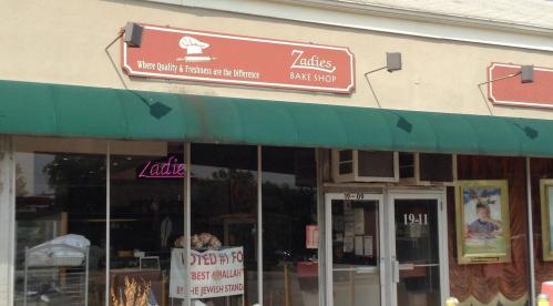 Exterior of Zadie's Bake Shop with a green awning and a sign highlighting quality and freshness.