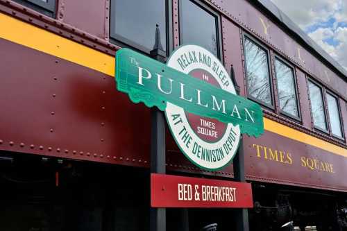 Sign for "The Pullman at the Dennison Depot" Bed & Breakfast, featuring a vintage train car in the background.