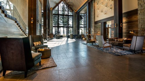 Spacious lodge lobby with large windows, modern seating, and a warm, inviting atmosphere. Natural light floods the space.
