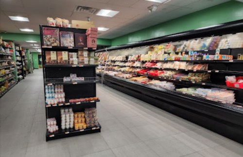 A grocery store aisle with shelves stocked with various food items and a display of packaged goods in the foreground.