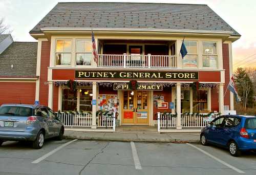 Exterior of Putney General Store, a two-story building with festive decorations and parked cars in front.