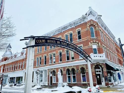 Historic brick building on a snowy street, featuring an arch sign for Court Avenue and decorative elements.