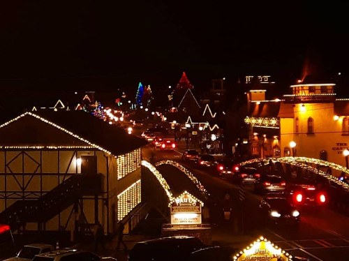 A festive street at night, adorned with colorful lights and decorations, creating a cheerful holiday atmosphere.