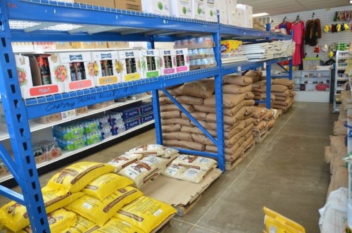 A grocery store aisle with blue shelves stocked with bags of rice and various food products.