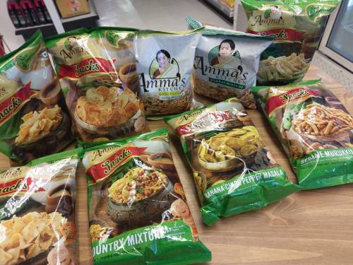 A variety of snack bags from Amma's Kitchen displayed on a table, featuring different flavors and textures.