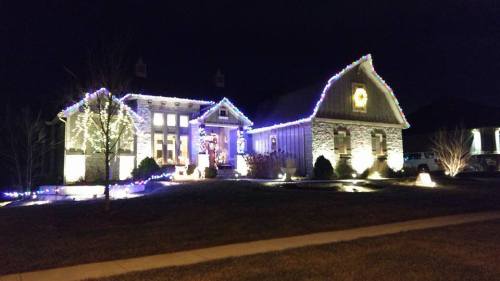 A beautifully decorated house at night, illuminated with colorful holiday lights and a festive atmosphere.