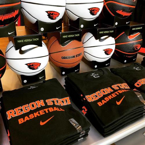 A display of Oregon State basketball merchandise, including shirts and various Nike basketballs.