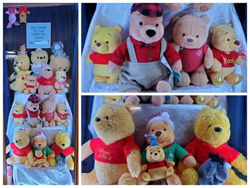 A display of various Winnie the Pooh plush toys in different sizes and outfits, arranged on a white backdrop.