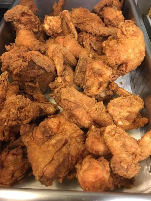 A tray filled with golden-brown, crispy fried chicken pieces.