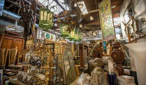 A cluttered antique shop filled with vintage decor, stained glass, lamps, and various collectibles.