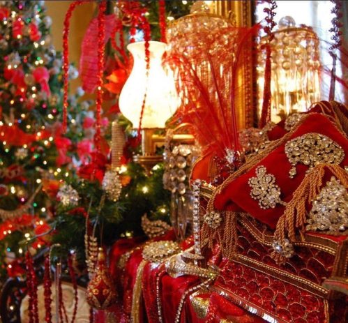 A festive display featuring red and gold decorations, sparkling lights, and a beautifully adorned Christmas tree.