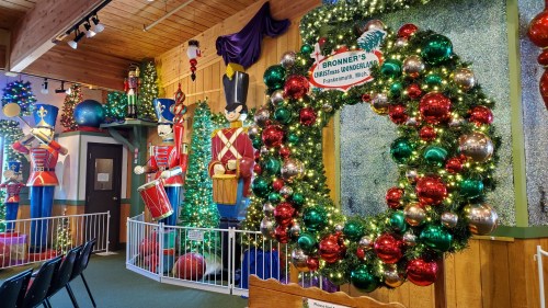 A festive display featuring a large wreath and colorful nutcracker figures, decorated with lights and ornaments.