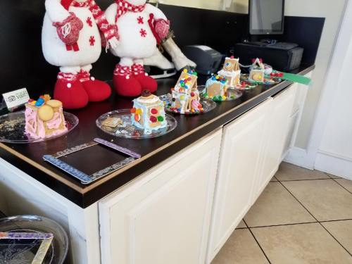 A countertop displays colorful gingerbread houses decorated with candy, alongside festive stuffed animals.