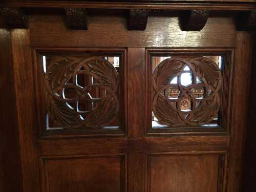 Intricately carved wooden door panels featuring floral designs and circular motifs.