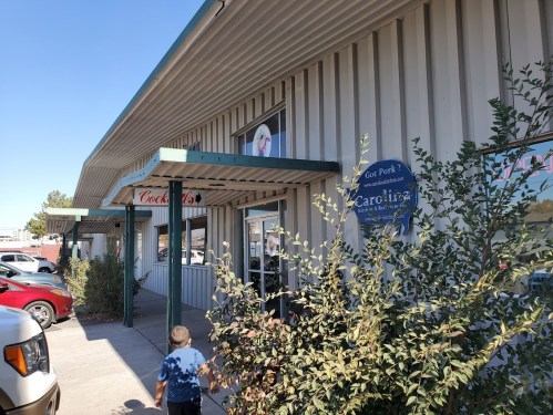 A child walks towards a building with a sign reading "Cocktail's" and a blue sign for "Carolina" nearby.