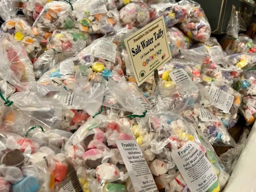 A display of colorful saltwater taffy bags, neatly arranged with labels, in a candy shop setting.