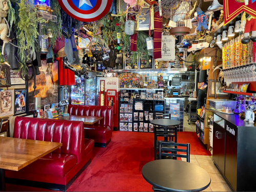 A vibrant restaurant interior with red booths, eclectic decor, and a colorful display of memorabilia and collectibles.