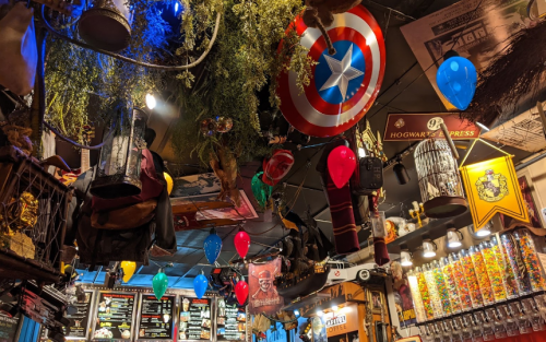 Colorful decorations and balloons hang from the ceiling, featuring a Captain America shield and various themed items.
