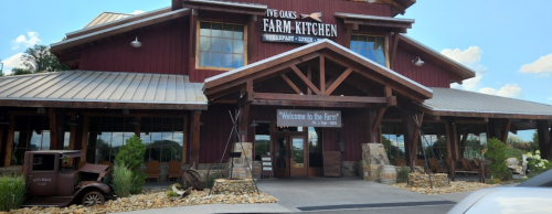 Exterior of Five Oaks Farm Kitchen, featuring a rustic wooden structure and a welcoming sign.