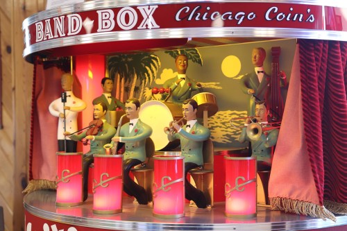 A vintage mechanical band box featuring colorful figurines playing instruments with illuminated drums.