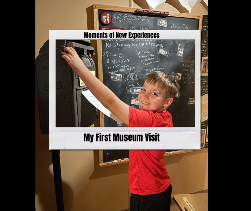 A young boy smiles while interacting with a museum exhibit, framed by a sign about his first museum visit.