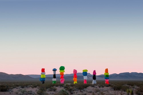 Colorful stacked boulders in a desert landscape against a pastel sky at dusk.