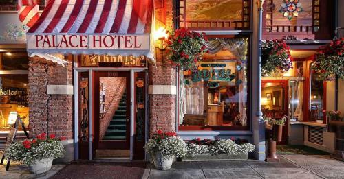 Exterior of the Palace Hotel, featuring a striped awning, vibrant flower baskets, and a welcoming entrance.