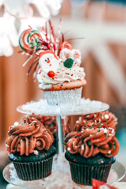 A festive display of cupcakes: one topped with Santa and colorful decorations, surrounded by chocolate frosted cupcakes.