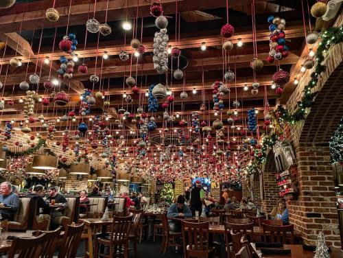 A festive restaurant interior decorated with hanging ornaments and garlands, creating a warm, holiday atmosphere.
