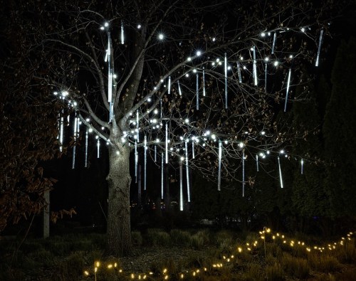 A tree adorned with glowing lights hanging like icicles, set against a dark night sky.