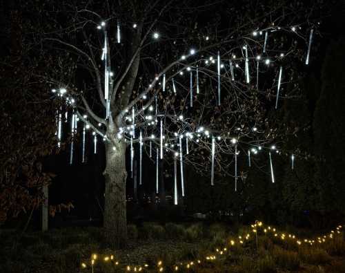 A tree adorned with glowing lights hanging like icicles, set against a dark night sky.