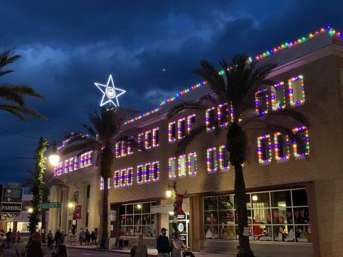 A building adorned with colorful holiday lights and a star on top, set against a dark, cloudy sky.