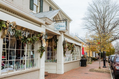 A charming storefront decorated for the holidays, featuring festive greenery and a sign that reads "Chloe's."
