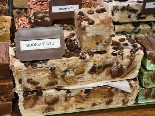 A display of fudge varieties, including a block labeled "Mooseprints" topped with chocolate chips.