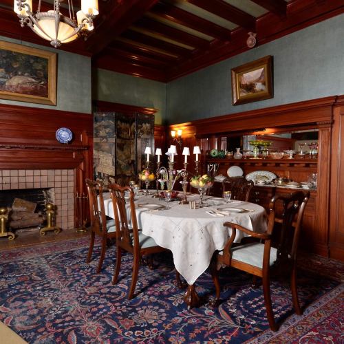 Elegant dining room with a wooden table set for a meal, surrounded by chairs and adorned with a chandelier and artwork.