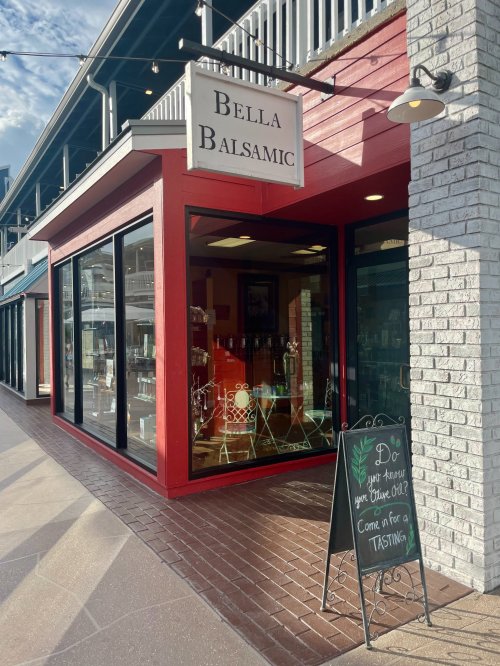 Exterior of Bella Balsamic store with large windows and a sign inviting customers for a tasting.