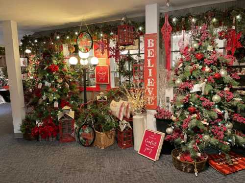 A festive display featuring decorated Christmas trees, red and white decor, and holiday-themed signs.