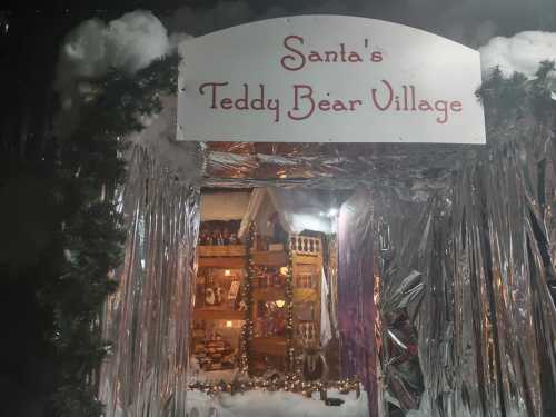 A festive entrance to "Santa's Teddy Bear Village," adorned with decorations and twinkling lights.