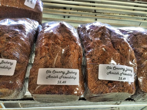 Loaves of bread wrapped in plastic, labeled "Ole Country Bakery Amish Friendship" with a price tag of $5.49.