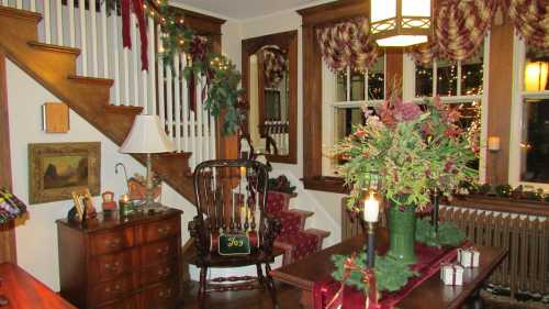 Cozy holiday living room with festive decorations, a rocking chair, and a beautifully arranged floral centerpiece.