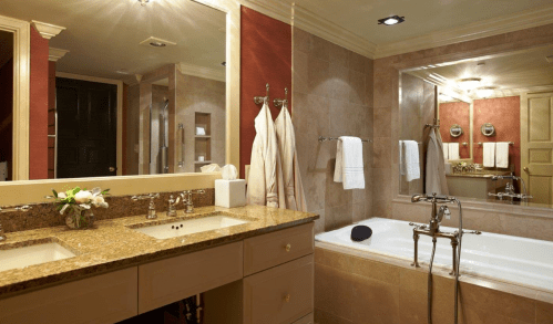 A luxurious bathroom featuring a double sink, a bathtub, and elegant decor with soft lighting.