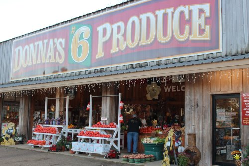 A produce store with a large sign reading "Donna's #6 Produce," featuring fresh fruits and vegetables outside.