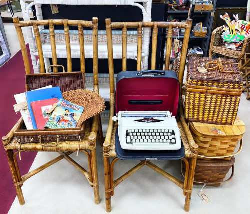 Two vintage bamboo chairs hold a typewriter, books, and woven baskets, creating a nostalgic display.