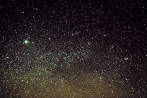 A vast night sky filled with countless stars, showcasing a deep cosmic expanse and a hint of the Milky Way.