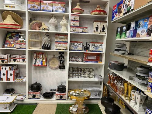 A store display featuring various decorative items, cookware, and traditional crafts on shelves.