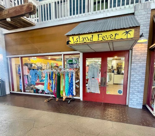 Storefront of "Island Fever" featuring colorful clothing displays and a welcoming entrance.