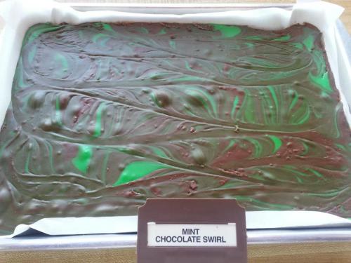 A tray of mint chocolate swirl dessert with green and brown swirls, labeled "Mint Chocolate Swirl."