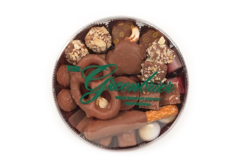 A round box filled with assorted chocolates, including pralines, chocolate-covered nuts, and various confections.